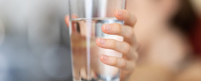 woman holding a fresh glass of water